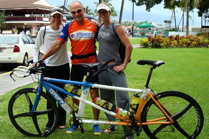 C Different athletes and guides gathered around a tandem bike.