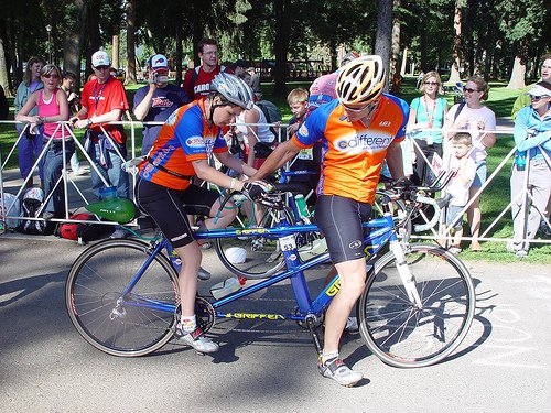 A tandem cycling team preparing in a race transition area.